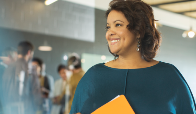 Woman with folder is smiling at a group