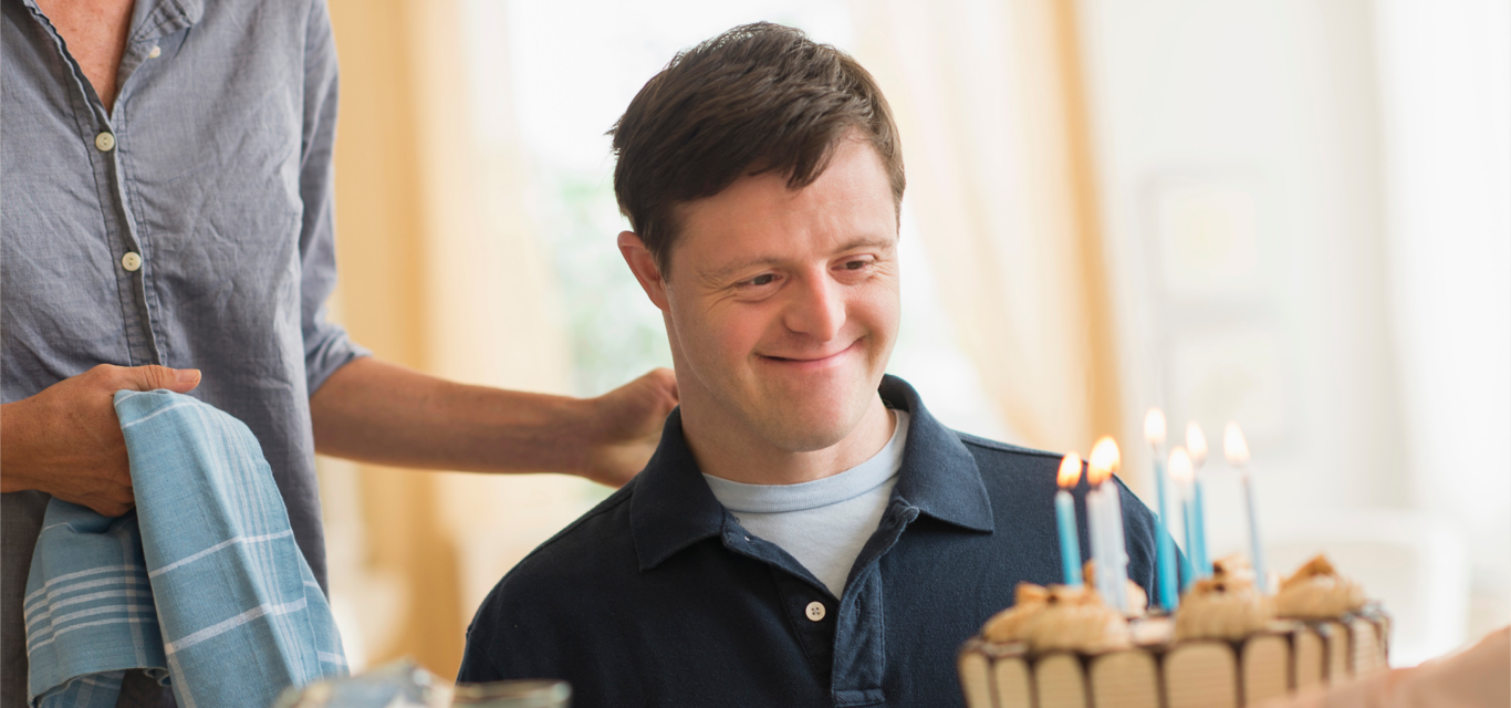 Man blowing out candles on cake